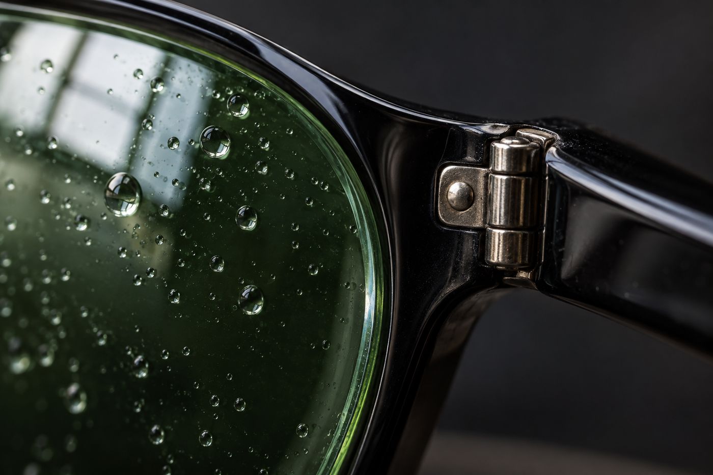 Detalle de una lente verde con gotas de agua